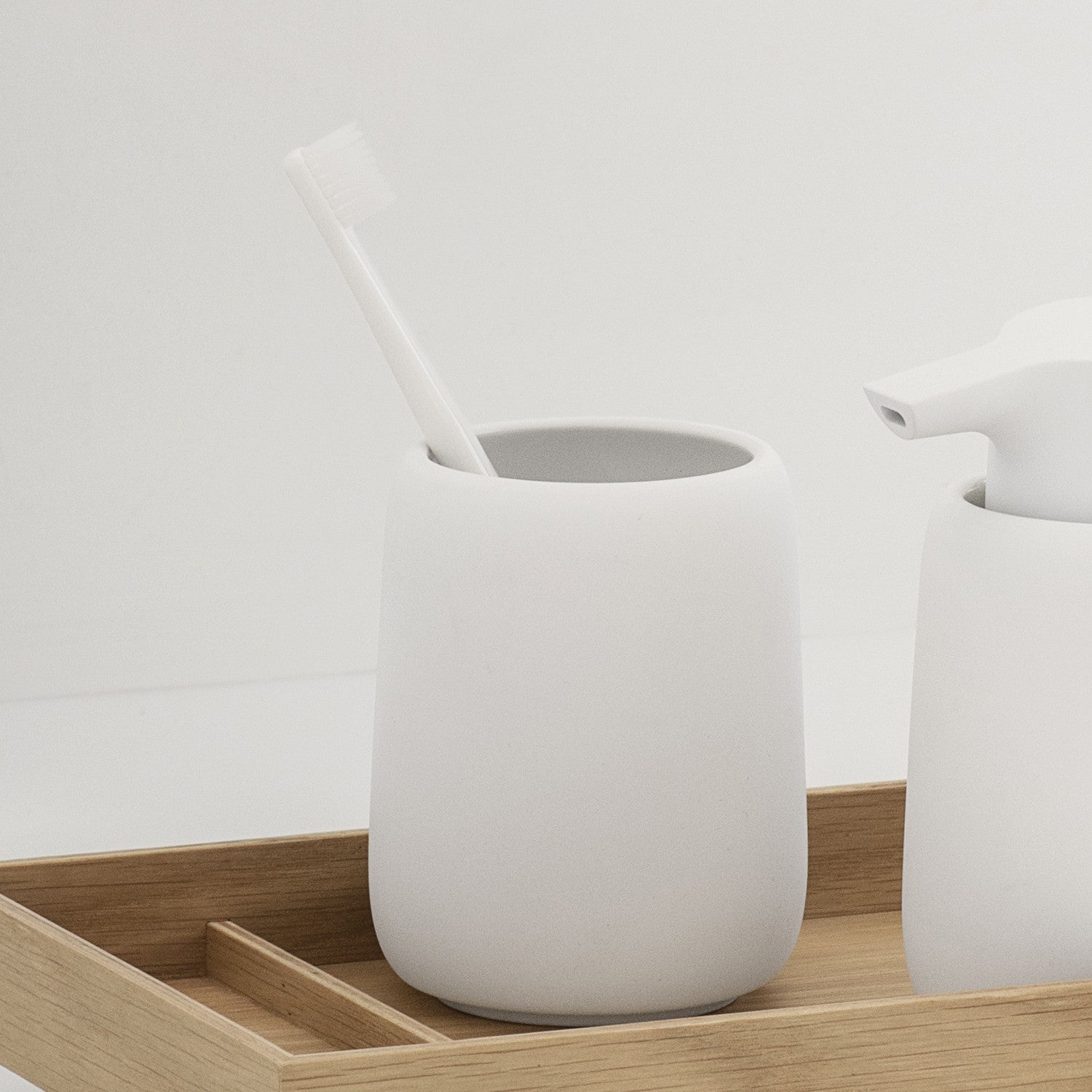 white tumbler for toothbrushes in bathroom